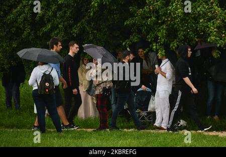 People shelter under a tree during rainy weather. A heavy rain remains in Krakow area and changeable weather with rain, thunderstorms and temperatures between 20 and 26 C degrees is predicted for the next week. On June 20, 2020, in Krakow, Poland. (Photo by Artur Widak/NurPhoto) Stock Photo