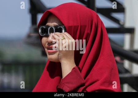 A student is seen observing a partial solar eclipse in Lhokseumawe, On June 21, 2020, Aceh Province, Indonesia. According to the Report, the Meteorology, Climatology and Geophysics Agency (BMKG), the path that the Ring Solar Eclipse passed on June 21 is Congo, South Sudan, Ethiopia, Yemen, Oman, Pakistan, India, China, and the Pacific Ocean, whereas in Indonesia it can be observed as a partial solar eclipse. (Photo by Fachrul Reza/NurPhoto) Stock Photo