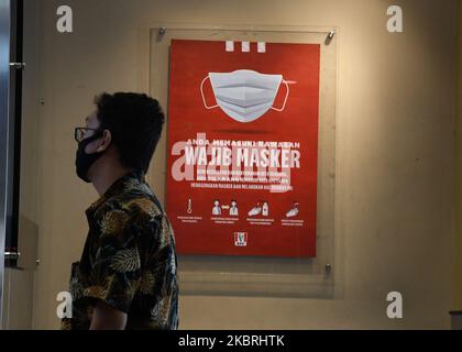 Waiters tidy up tables and draw KFC (Kentucky Fried Chicken) characters around tables and benches, in Salemba, Jakarta, on June, 24,2020. The character banner is used as a barrier for visitors who eat on the spot during the new normality phase. (Photo by Dasril Roszandi/NurPhoto) Stock Photo