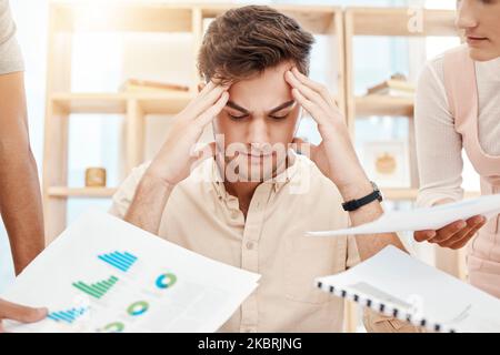 Stress, young man and headache being overworked, upset and tired in office. Business, employee and male experience burnout, frustrated and depressed Stock Photo