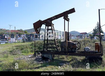 ALBANIA, Kuçova, named Stalin city from 1950 to1991, crude oil field and old drilling pump at cemetery, still operating and polluting the environment / ALBANIEN, Kucova, von 1950 bis 1991 Qyteti Stalin, Stalinstadt, Erdoelfoerderung, alte Oelfoerderpumpe, die heute noch zur Ölförderung in Betrieb sind, an einem Friedhof Stock Photo