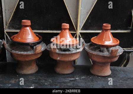 Clay tagine pots containing chicken tagine cook on coals at a restaurant in the souk in the medina (old city) of Marrakesh (Marrakech) in Morocco, Africa. Marrakesh is the fourth largest city in the Kingdom of Morocco. (Photo by Creative Touch Imaging Ltd./NurPhoto) Stock Photo