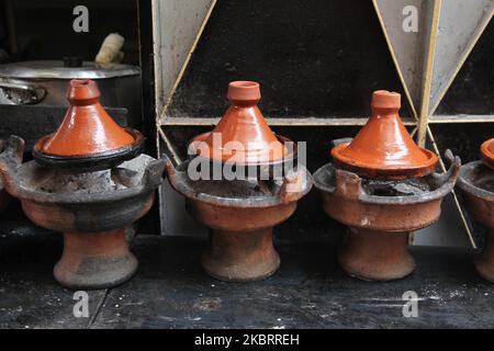 Clay tagine pots containing chicken tagine cook on coals at a restaurant in the souk in the medina (old city) of Marrakesh (Marrakech) in Morocco, Africa. Marrakesh is the fourth largest city in the Kingdom of Morocco. (Photo by Creative Touch Imaging Ltd./NurPhoto) Stock Photo