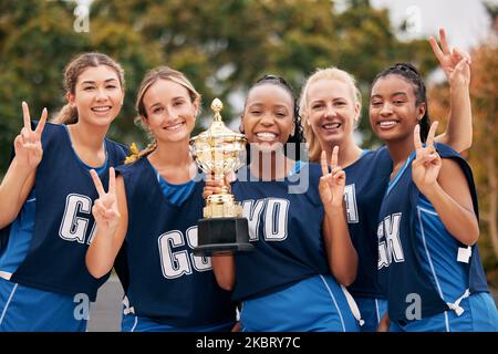 Sports, netball and trophy with a woman team in celebration as a winner group of a victory or achievement. Peace, winning and teamwork with a female Stock Photo