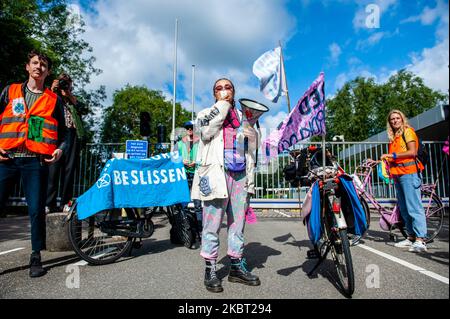 An Extinction Rebellion activist is giving a speech in front of the doors of KLM headquarters, during the Extinction Rebellion bicycle campaign against KLM support package, in Amsterdam, Netherlans on July 3, 2020. (Photo by Romy Arroyo Fernandez/NurPhoto) Stock Photo