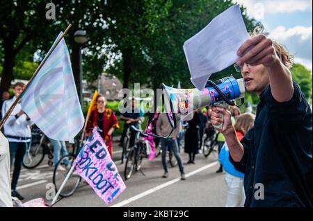 An Extinction Rebellion activist is giving a speech in front of the doors of KLM headquarters, during the Extinction Rebellion bicycle campaign against KLM support package, in Amsterdam, Netherlans on July 3, 2020. (Photo by Romy Arroyo Fernandez/NurPhoto) Stock Photo