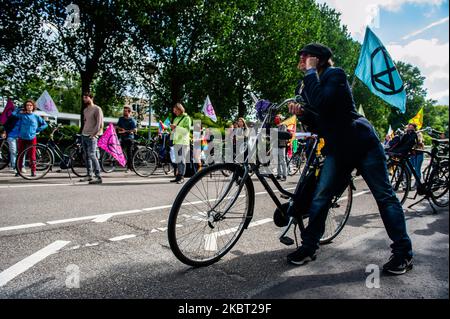 Climate activists are listening the speeches given at the KLM headquarters, during the Extinction Rebellion bicycle campaign against KLM support package, in Amsterdam, Netherlans on July 3, 2020. (Photo by Romy Arroyo Fernandez/NurPhoto) Stock Photo