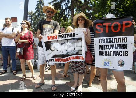 Anti-vaccination protesters hold placards during all-Ukrainian protest rally called 'For the family! For the rights of the child! Against medical tyranny' near the Ukrainian Parliament in center of Kyiv, Ukraine, on 03 July, 2020. The participants of 'Vaccination: Free Choice' movement and their supporters protest against a bill, the adoption of which, according to activists, can deprive parents of the right to denied medical interventions to children. ' (Photo by STR/NurPhoto) Stock Photo