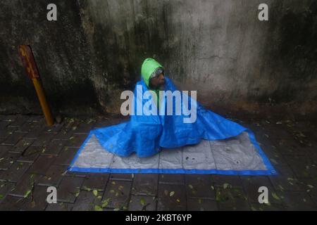 A beggar covers himself from rain in Mumbai, India on July 07, 2020. Monsoon in India officially lasts from June to September. (Photo by Himanshu Bhatt/NurPhoto) Stock Photo