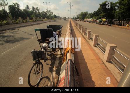 A homeless rickshaw puller rests on the approach of an overpass bridge road in between the COVID-19 coronavirus lockdown period in the eastern Indian state Odisha's capital city Bhubaneswar, on July 9, 2020. (Photo by STR/NurPhoto) Stock Photo