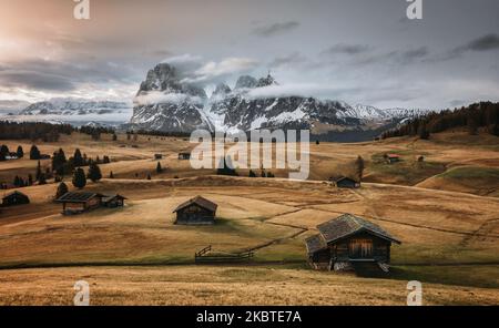 Mountain meadow with little huts and mountains views Stock Photo
