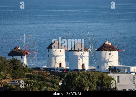 Early morning panoramic view of the windmills and Mykonos Town, the overview is seen from a hill. The iconic windmills in Mykonos island, Cyclades islands, Aegean Sea, Greece on July 14, 2020. There are 16 windmills on the island, 5 of them above Chora or Mykonos Town, the main town on the island. The windmills were built in the 16th century from the Venetians but their constructions continued until the 20th century. The famous Mediterranean Greek island is nicknamed as The Island of the Winds with whitewashed traditional buildings like windmills or little church. Mykonos is popular island for Stock Photo