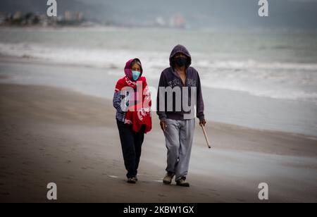 The citizens of Tonsupa in the province of Esmeraldas Ecuador, on July 21, 2020, remains in constant fear of the new SARS COV2 virus, on this beach request government help to cope with the food and economic need that arose in this Andean country after it remains in almost four months in quarantine. In view of the fact that the Lenin Moreno government does not do something or offer help, several fishermen go out to sea to fish and then reach the shore and supply the most needy, they assure that they will get ahead as usual. Several citizens push the canoes that go out to do this work in gratitu Stock Photo