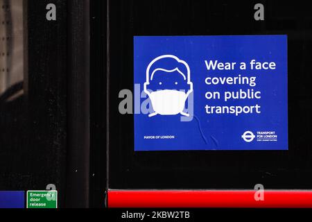 A sign telling passengers to wear a face covering covers covers past of the window of a bus parked on Whitehall in London, England, on July 22, 2020. UK retail sales data for June, during which non-essential shops were allowed to reopen, is set to be released by the Office for National Statistics (ONS) this Friday, July 24. The day will also be the first that people in England will be required to wear face masks or other kinds of face covering in shops and supermarkets. Face coverings on public transport have been compulsory across England since mid-June. (Photo by David Cliff/NurPhoto) Stock Photo