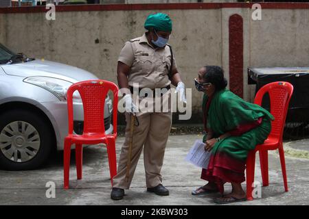 A police officer speaks to a woman who waits for a medical check-up in Mumbai, India on July 22, 2020. India has become the third country after the United States and Brazil, to cross 01 million COVID-19 cases. (Photo by Himanshu Bhatt/NurPhoto) Stock Photo