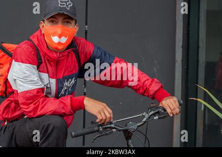 A delivery worker from Rappi, a delivery app company uses a face mask with the company logo during the sectorized lockdowns amid the novel Coronavirus pandemic in Bogota, Colombia, on July 22, 2020. (Photo by Sebastian Barros/NurPhoto) Stock Photo