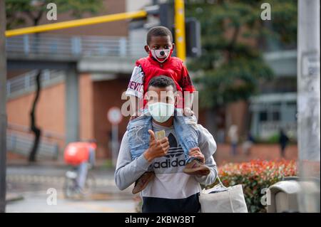 A men carries his son on his shoulders while both wear protective face masks during the sectorized lockdowns amid the novel Coronavirus pandemic in Bogota, Colombia, on July 22, 2020. (Photo by Sebastian Barros/NurPhoto) Stock Photo