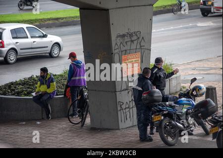 Bikers and motorcyclists wait under a bridge for rain to ease while wearing protective face masks during the sectorized lockdowns amid the novel Coronavirus pandemic in Bogota, Colombia, on July 22, 2020. (Photo by Sebastian Barros/NurPhoto) Stock Photo