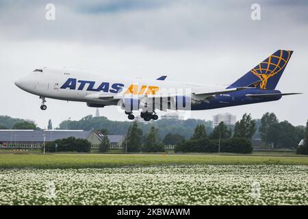 Atlas Air Boeing 747 Freighter, a Cargo aircraft as seen on final approach flying and landing with smoke after the touch down at Amsterdam Schiphol AMS EHAM international airport in the Netherlands on July 2, 2020. The double-decker Jumbo Jet is known as Queen of the skies operates in a freight edition with the registration N492MC, is powered by 4x GE jet engines and has the specific type 747-47U(F). AtlasAir 5Y GTI GIANT is an American cargo and passenger charter airliner subsidiary of Atlas Air Worldwide Holdings based in Purchase, Harrison New York in the USA. Cargo flights increased during Stock Photo