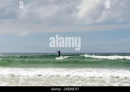 Newquay, United Kingdom - 4 Spetember, 2022: surfer catching a wave at Fistral Beach in Newquay Stock Photo