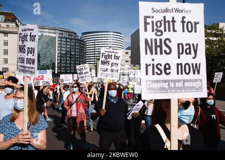 National Health Service (NHS) staff, protesting their exclusion from a recently-announced public sector pay rise, demonstrate outside St Thomas' Hospital in London, England, on July 29, 2020. Around 900,000 public sector workers across the UK are set to receive above-inflation pay rises this year as a gesture of thanks from the Treasury for their efforts during the coronavirus pandemic. Within the NHS, doctors and dentists will benefit from the rises, but nurses and other frontline staff have been excluded owing to a three-year pay deal they negotiated in 2018. Nursing activists say that so-ca Stock Photo