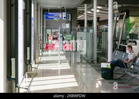 Passengers waiting with facemask, checking in at the counter for boarding and empty seats with signs blocking them inside the gates area with reduced traffic. Flying from Athens International Airport ATH LGAV in Greece. Passengers with facemasks and protective measures as gloves, hand sanitizer, blocking seats, applying social distancing, distance signs etc because of the Coronavirus Covid-19 Pandemic outbreak, safety measures, as seen at the check-in counters, main departure terminal, at the gates. Athens, Greece - July 2020 (Photo by Nicolas Economou/NurPhoto) Stock Photo