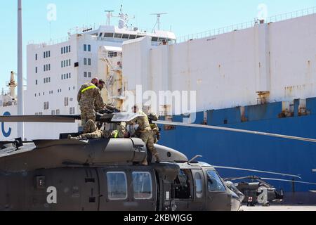 United States of America Army Troops assembly and fix their helicopters after unloading them from ARC ship at the port of Alexandroupoli. Troops of the 101st Airborne Combat Aviation in uniform on duty working on the helicopters and wearing facemasks as safety preventive measures against the spread of Coronavirus Covid-19 Pandemic outbreak. The 101 CAB Brigade of the army of the USA arrives at the port of Alexandroupolis in Greece to deploy soldiers, manpower, troops, vehicles and helicopters for Atlantic Resolve 2020 NATO military exercise. On July 23, 2020 in Alexandroupoli, Greece. (Photo b Stock Photo