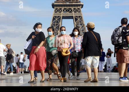 Tourists wearing a protective mask walk a front the Eiffel Tower in France. On August 2, 2020. (Photo by Mehdi Taamallah/NurPhoto) Stock Photo