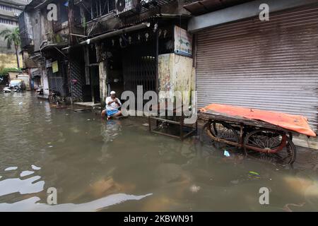 A man uses a mobile phone as he sits in front of his house in a flooded street in Mumbai, India on August 04, 2020. (Photo by Himanshu Bhatt/NurPhoto) Stock Photo