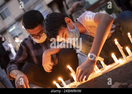 An Iranian boy wearing a protective face mask lights candle on a street-side in front of the Lebanon embassy in central Tehran, as a symbol of the Iranian people's sympathy for the victims of the recent explosions in Beirut, on August 5, 2020. (Photo by Morteza Nikoubazl/NurPhoto) Stock Photo