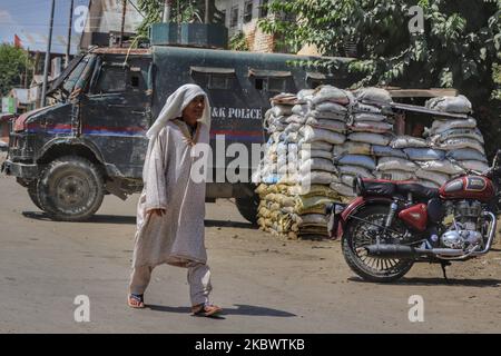 An Elderly Kashmiri woman walks past an Armored Police Vehicle amid COVID-19 Pandemic in Sopore Town of District Baramulla, Jammu and Kashmir, India some 50 KMS from Summer capital Srinagar on 07 August 2020. (Photo by Nasir Kachroo/NurPhoto)