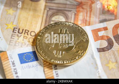 Bitcoin golden physical coin illustration on Euro banknotes of 20 and 50 euros. visual representations of the digital Cryptocurrency Bitcoin with the Euro bill. Bitcoin is a popular digital currency that showed growth and is widely spread, accepted from banks, markets and other services and shops as ways of payments. The exchange rate today for 1 bitcoin blockchain is 9969 euros. Thessaloniki, Greece - August 8, 2020 (Photo by Nicolas Economou/NurPhoto) Stock Photo
