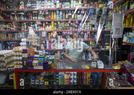 An Iranian shopkeeper wearing a protective face mask works at his local supermarket in Tehran’s business district while standing behind a divider, following the new coronavirus (COVID-19) outbreak in Iran. (Photo by Morteza Nikoubazl/NurPhoto) Stock Photo