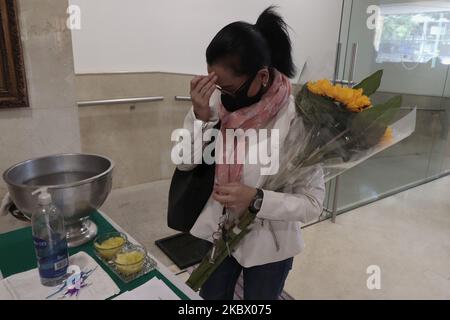 A woman from the Lebanese community in Mexico, with a sunflower enters the Parish of Our Lady of Lebanon in Mexico City, Mexico on August 9, 2020 during mass in memory of the victims after the explosion in the port of Beirut, Lebanon. (Photo by Gerardo Vieyra/NurPhoto) Stock Photo