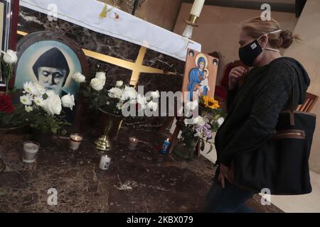 A woman from the Lebanese community in Mexico leaves flowers in front of the San Charbel altar inside the Parroquia de Nuestra Señora de Líbano in Mexico City, Mexico on August 9, 2020 in memory of the victims after an explosion in the port of Beirut, Lebanon. (Photo by Gerardo Vieyra/NurPhoto) Stock Photo