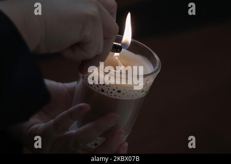 A woman from the Lebanese community in Mexico lights candles to the Parish of Our Lady of Lebanon in Mexico City, Mexico on August 9, 2020 during mass in memory of the victims after the explosion in the port of Beirut, Lebanon. (Photo by Gerardo Vieyra/NurPhoto) Stock Photo