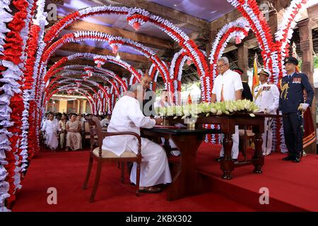 Chamal Rajapaksa (L), the elder brother of prime minister Mahinda Rajapaksa signs official documents before taking oaths to be appointed as Sri Lanka's cabinet minister of Irrigation and state minister of Internal Security by his younger brother, president Gotabaya Rajapaksa while prime minister, Mahinda Rajapaksa (2L) looks on during an event for the swearing in of the new cabinet ministers at the historical “Magul Maduwa”/ 'Assembly Hall' situated at the Temple of the Sacred Tooth Relic where the ancient Sri Lankan kings met their ministers and carried out daily administrative tasks at Kandy Stock Photo