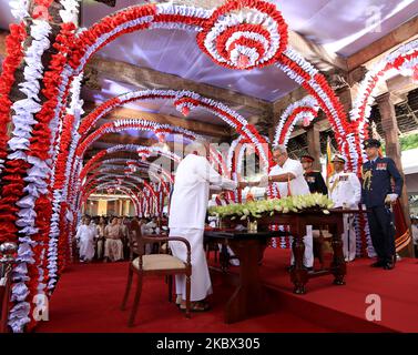 Chamal Rajapaksa (L), the elder brother of prime minister Mahinda Rajapaksa receives the official documents after taking oaths to be appointed as Sri Lanka's cabinet minister of Irrigation and state minister of Internal Security by his younger brother, president Gotabaya Rajapaksa while prime minister, Mahinda Rajapaksa looks on during an event for the swearing in of the new cabinet ministers at the historical â€œMagul Maduwaâ€/ 'Assembly Hall' situated at the Temple of the Sacred Tooth Relic where the ancient Sri Lankan kings met their ministers and carried out daily administrative tasks at  Stock Photo