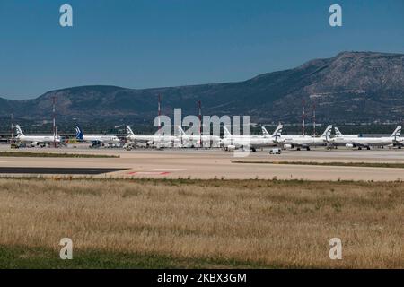 The grounded Airbus A320 family fleet of passenger aircraft of Aegean Airlines as seen parked at Athens International Airport ATH LGAV in the Greek capital. Aegean Airlines is the flag carrier of Greece based with a hub in Athens. The airplanes are not flying due to the Covid pandemic outbreak. Many of the planes have their jet engines covered with a red cover. Covid-19 cases skyrocket in Greece the past few days as tourists and locals are more relaxed without keeping the social distancing and mandatory safety measures such as protective mask during their summer holidays in tourist destination Stock Photo