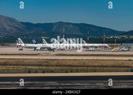 The grounded Airbus A320 family fleet of passenger aircraft of Aegean Airlines as seen parked at Athens International Airport ATH LGAV in the Greek capital. Aegean Airlines is the flag carrier of Greece based with a hub in Athens. The airplanes are not flying due to the Covid pandemic outbreak. Many of the planes have their jet engines covered with a red cover. Covid-19 cases skyrocket in Greece the past few days as tourists and locals are more relaxed without keeping the social distancing and mandatory safety measures such as protective mask during their summer holidays in tourist destination Stock Photo