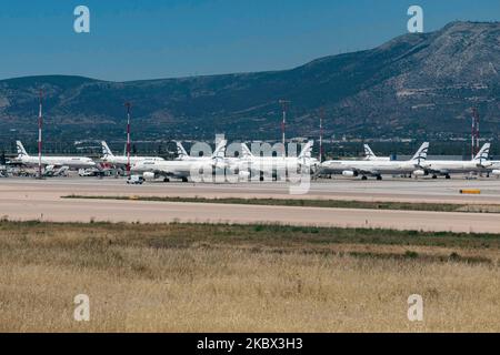 The grounded Airbus A320 family fleet of passenger aircraft of Aegean Airlines as seen parked at Athens International Airport ATH LGAV in the Greek capital. Aegean Airlines is the flag carrier of Greece based with a hub in Athens. The airplanes are not flying due to the Covid pandemic outbreak. Many of the planes have their jet engines covered with a red cover. Covid-19 cases skyrocket in Greece the past few days as tourists and locals are more relaxed without keeping the social distancing and mandatory safety measures such as protective mask during their summer holidays in tourist destination Stock Photo