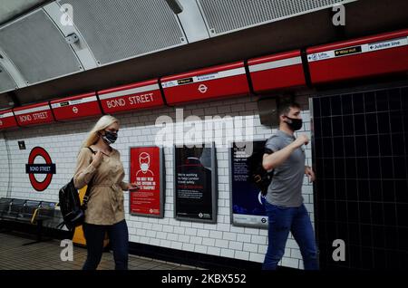 Passengers wearing face masks, currently mandated on public transport, walk along a Central line platform at Bond Street station in London, England, on August 14, 2020. Passenger numbers on the London Underground remain well below pre-pandemic levels as the city continues its hesitant emergence from the coronavirus lockdown, with covid-19 fears still keeping many from using public transport. (Photo by David Cliff/NurPhoto) Stock Photo