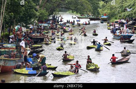 Farmers row boats loaded with guavas on their way to a floating market in Barisal, Bangladesh on August 16, 2020. Thousands of farmers earn their livelihood growing and selling these guavas. Guava, a berry-like fruit, is often called the 'apple of the tropics'. Although it originated in tropical America (in the land between Mexico and Peru), today it is one of the important fruit crops of Bangladesh, where itâ€™s grown all over the country. The southern region of Bangladesh, especially districts of Barisal, Pirojpur, and Jhalbokathi, are the main Guava-producing areas. Nobody is certain when e Stock Photo