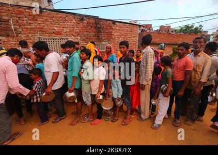People stand in queue as Rashtriya Sawam Sangh (RSS) members distribute food at landslide affected areas after the following heavy rainfall at Sundar Nagar Ganesh Vihar colony,Lal Dungari , in Jaipur, Rajasthan, India, Aug 16,2020.(Photo by Vishal Bhatnagar/NurPhoto) Stock Photo