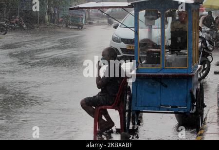 Commuters, vehicles and other pedestrians are seen seen on the road in the downpour time in the eastern Indian state Odisha's capital city Bhubaneswar, on August 19, 2020. After back-to-back low pressure systems have left parts of Odisha battling flash floods, the India Meteorological Department (IMD)'s forecast for heavy showers in 12 districts likely to be caused by a fresh system developing over Bay Bengal could add to the woes of the State. The weather office on Tuesday already sounded an orange alert. (Photo by STR/NurPhoto) Stock Photo