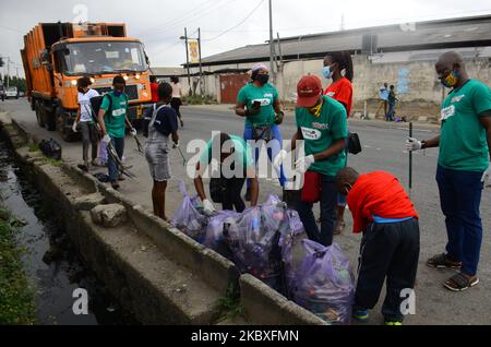 Groups of volunteers picking waste on the road sides and drainages in Lagos, Nigeria on August 23, 2020. A non-governmental organization African Clean-Up Initiative (ACI) partnered with NGOâ€™s and volunteers to clean up motor parks in Town Planning Way, Oshodi under bridge, Anthony and Ilupeju and also clean up 13 streets along Ilupeju, Oshodi area. A global social action program aimed at combating the global solid waste problem, in preparation toward expected rainfall and flood in Nigeria. (Photo by Olukayode Jaiyeola/NurPhoto) Stock Photo