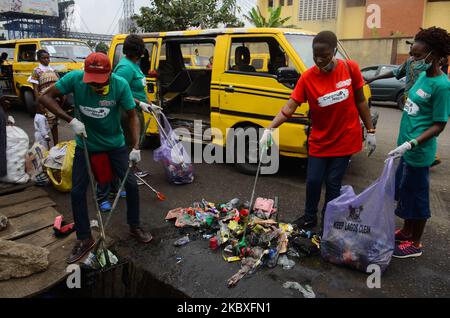 Groups of volunteers picking waste on the road sides and drainages in Lagos, Nigeria on August 23, 2020. A non-governmental organization African Clean-Up Initiative (ACI) partnered with NGOâ€™s and volunteers to clean up motor parks in Town Planning Way, Oshodi under bridge, Anthony and Ilupeju and also clean up 13 streets along Ilupeju, Oshodi area. A global social action program aimed at combating the global solid waste problem, in preparation toward expected rainfall and flood in Nigeria. (Photo by Olukayode Jaiyeola/NurPhoto) Stock Photo