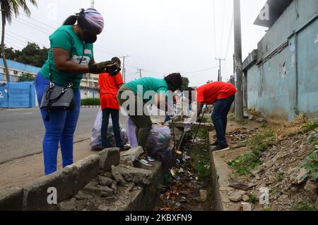 Groups of volunteers picking waste on the road sides and drainages in Lagos, Nigeria on August 23, 2020. A non-governmental organization African Clean-Up Initiative (ACI) partnered with NGOâ€™s and volunteers to clean up motor parks in Town Planning Way, Oshodi under bridge, Anthony and Ilupeju and also clean up 13 streets along Ilupeju, Oshodi area. A global social action program aimed at combating the global solid waste problem, in preparation toward expected rainfall and flood in Nigeria. (Photo by Olukayode Jaiyeola/NurPhoto) Stock Photo