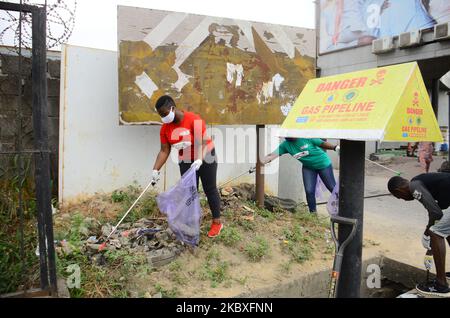 Groups of volunteers picking waste on the road sides and drainages in Lagos, Nigeria on August 23, 2020. A non-governmental organization African Clean-Up Initiative (ACI) partnered with NGOâ€™s and volunteers to clean up motor parks in Town Planning Way, Oshodi under bridge, Anthony and Ilupeju and also clean up 13 streets along Ilupeju, Oshodi area. A global social action program aimed at combating the global solid waste problem, in preparation toward expected rainfall and flood in Nigeria. (Photo by Olukayode Jaiyeola/NurPhoto) Stock Photo