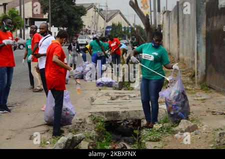 Groups of volunteers picking waste on the road sides and drainages in Lagos, Nigeria on August 23, 2020. A non-governmental organization African Clean-Up Initiative (ACI) partnered with NGOâ€™s and volunteers to clean up motor parks in Town Planning Way, Oshodi under bridge, Anthony and Ilupeju and also clean up 13 streets along Ilupeju, Oshodi area. A global social action program aimed at combating the global solid waste problem, in preparation toward expected rainfall and flood in Nigeria. (Photo by Olukayode Jaiyeola/NurPhoto) Stock Photo